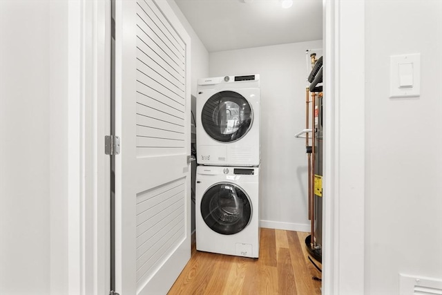 washroom with laundry area, stacked washer / dryer, and light wood-style floors