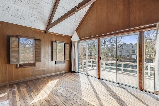 unfurnished sunroom featuring beam ceiling and a healthy amount of sunlight