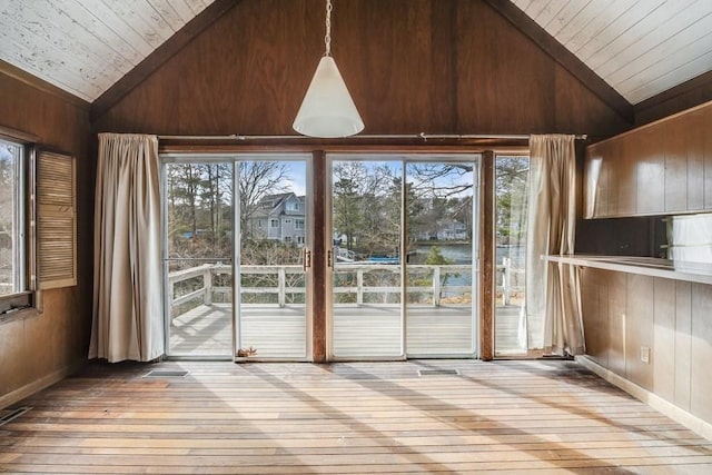 interior space featuring wood walls, wood-type flooring, and vaulted ceiling