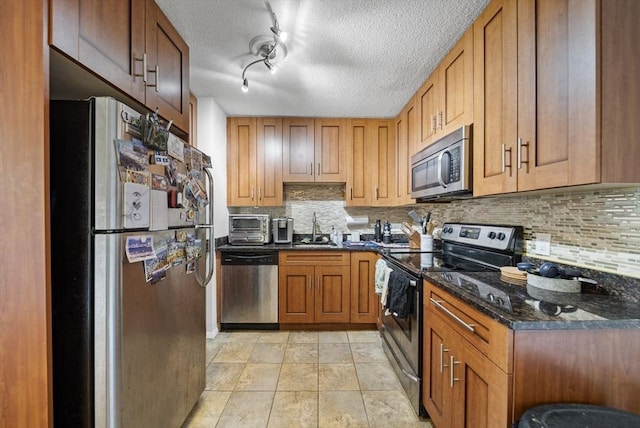 79 Poplar St Unit 10, Boston, MA 02131 - kitchen featuring appliances with stainless steel finishes, a sink, decorative backsplash, a textured ceiling, and brown cabinets