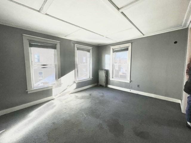 unfurnished room featuring baseboards, carpet flooring, and radiator