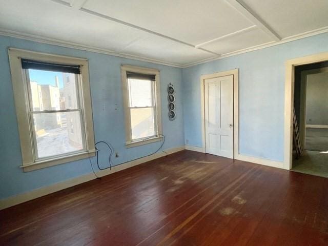 unfurnished room featuring crown molding, baseboards, and wood finished floors