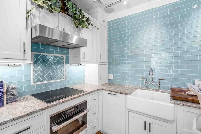 8 S St, Dennis, MA 02639 - kitchen with stainless steel oven, black electric cooktop, under cabinet range hood, backsplash, and a sink