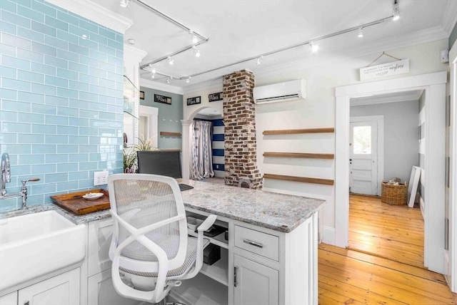 8 S St, Dennis, MA 02639 - home office with decorative columns, a wall mounted air conditioner, crown molding, a sink, and light wood-style floors