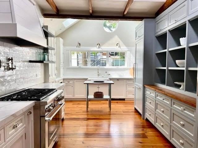8 S St, Dennis, MA 02639 - kitchen with high end appliances, a sink, light wood finished floors, open shelves, and tasteful backsplash