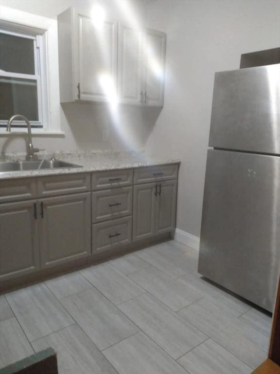 129 Marchand St, Fall River, MA 02723 - kitchen featuring freestanding refrigerator, a sink, gray cabinetry, and baseboards