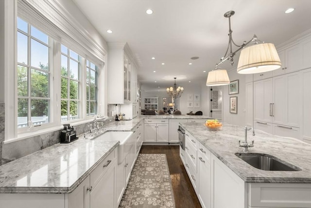 kitchen with a sink, recessed lighting, white cabinetry, dark wood-style floors, and decorative light fixtures