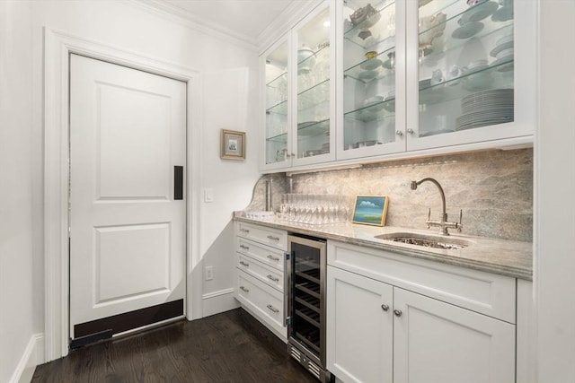 indoor bar featuring beverage cooler, crown molding, dark wood finished floors, backsplash, and baseboards