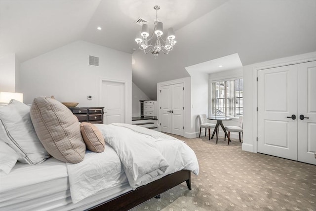 bedroom with two closets, vaulted ceiling, light colored carpet, a chandelier, and recessed lighting