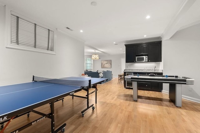 recreation room with ornamental molding, light wood-style floors, baseboards, and recessed lighting
