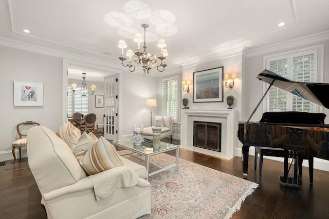 living room with a chandelier, a fireplace with flush hearth, baseboards, wood finished floors, and crown molding