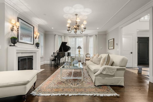 living room with a chandelier, dark wood-style flooring, a fireplace, recessed lighting, and ornamental molding
