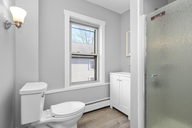 bathroom featuring hardwood / wood-style floors, toilet, walk in shower, and a baseboard heating unit