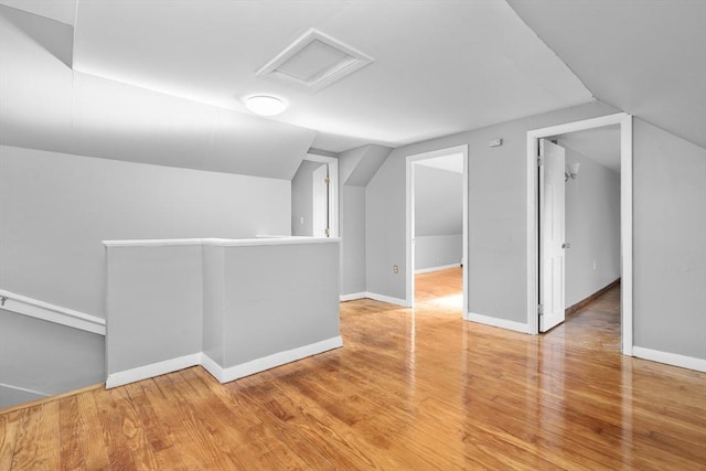 bonus room with hardwood / wood-style floors and vaulted ceiling