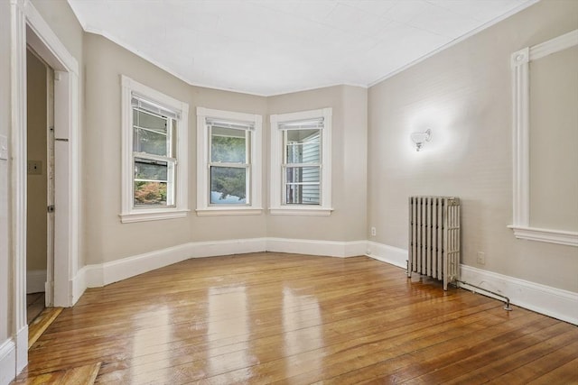 spare room with radiator, light hardwood / wood-style flooring, and ornamental molding