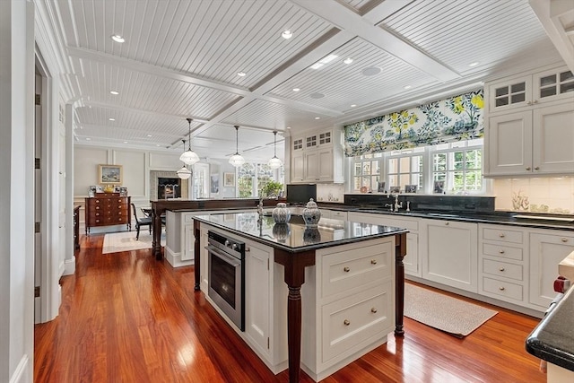29 Willard Cmn, Concord, MA 01742 - kitchen with dark wood-style flooring, healthy amount of natural light, glass insert cabinets, white cabinets, and beam ceiling