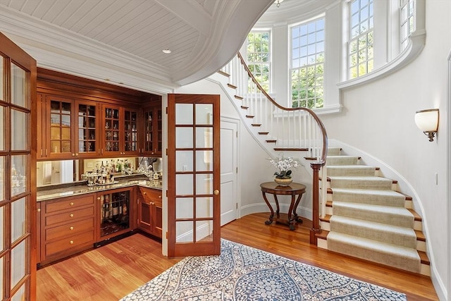 29 Willard Cmn, Concord, MA 01742 - indoor wet bar with wine cooler, stairway, light wood-type flooring, baseboards, and ornamental molding