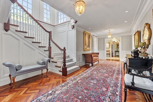 29 Willard Cmn, Concord, MA 01742 - foyer featuring a decorative wall, stairway, arched walkways, ornamental molding, and wainscoting