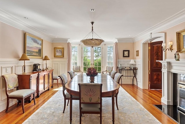 29 Willard Cmn, Concord, MA 01742 - dining space featuring a decorative wall, light wood-type flooring, ornamental molding, wainscoting, and a fireplace with flush hearth