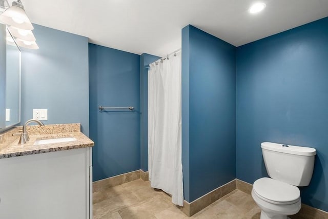 bathroom with baseboards, vanity, toilet, and curtained shower