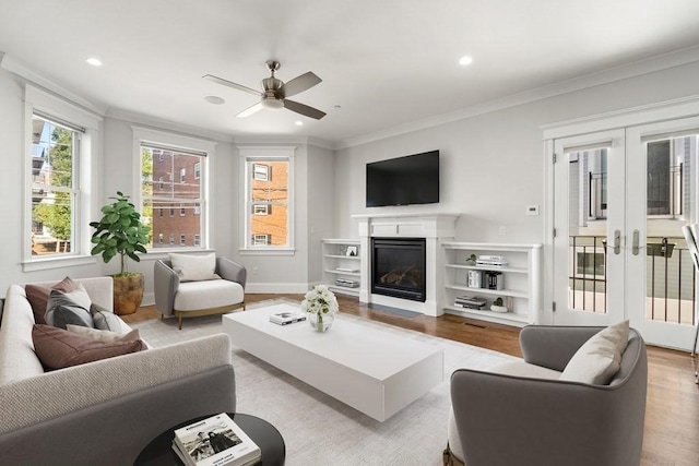 living room featuring crown molding, french doors, ceiling fan, and wood finished floors