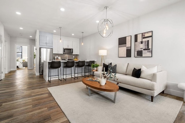 living room featuring sink and dark hardwood / wood-style flooring