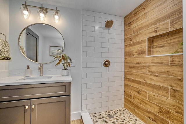 bathroom featuring vanity, wooden walls, and tiled shower