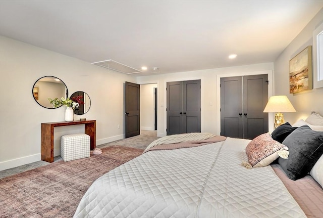 bedroom with multiple closets and light carpet