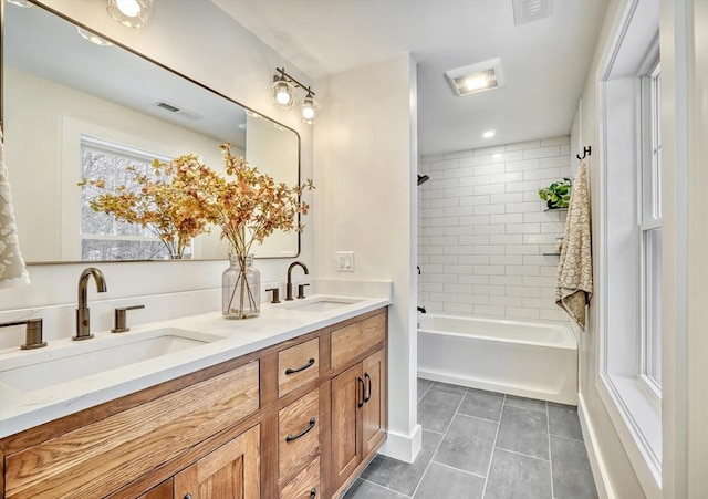 bathroom featuring tiled shower / bath, vanity, and tile patterned flooring