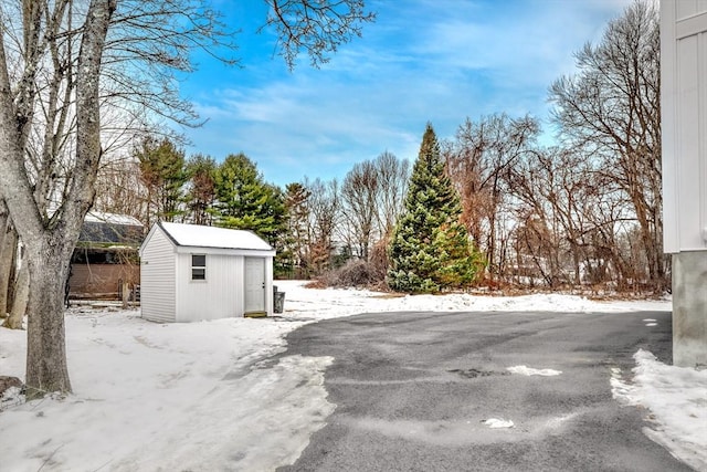 snowy yard featuring a shed