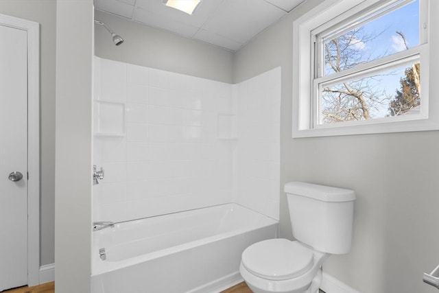 full bath with  shower combination, baseboards, and toilet