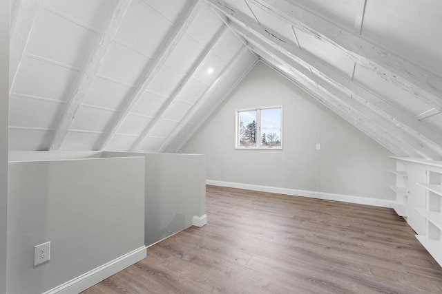 bonus room featuring vaulted ceiling, baseboards, and wood finished floors