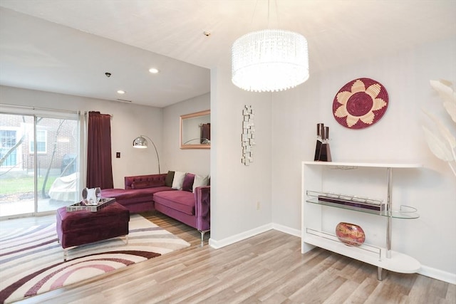 living room with a chandelier and light wood-type flooring