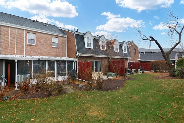 back of property featuring a sunroom, a yard, and cooling unit