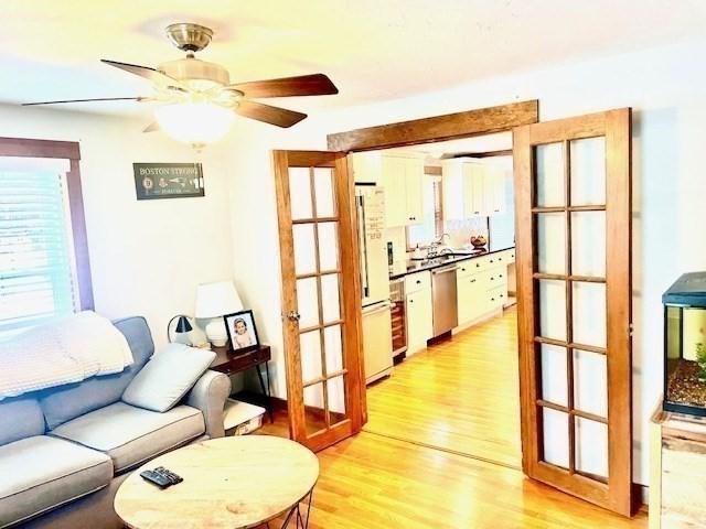 living room featuring light wood-type flooring and ceiling fan