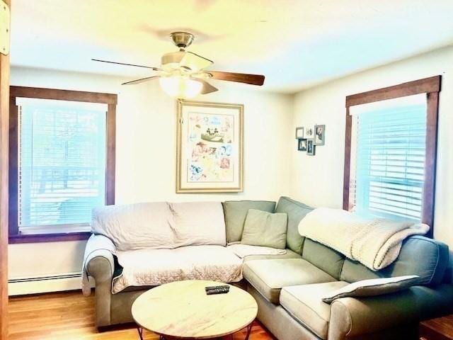 living area featuring a baseboard radiator, light wood-style flooring, and a ceiling fan