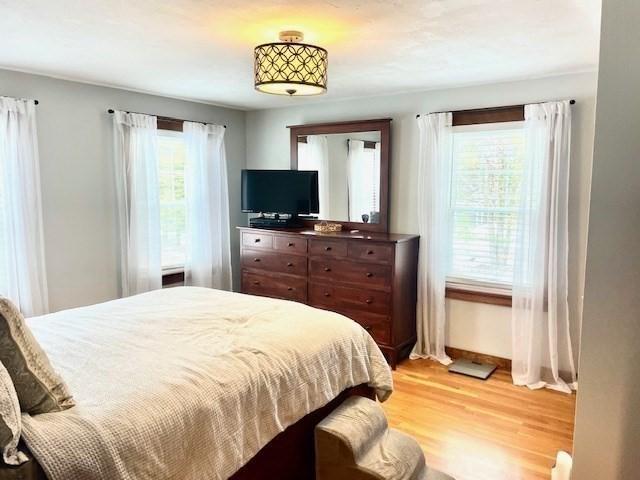 bedroom with light wood finished floors and baseboards