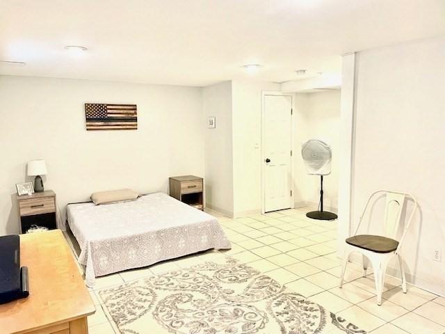 bedroom featuring a closet, baseboards, and light tile patterned floors