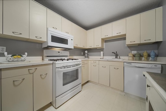 34 Newhall St Unit 313, Lowell, MA 01852 - kitchen with a textured ceiling, cream cabinets, sink, and white appliances