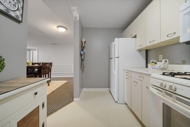 34 Newhall St Unit 313, Lowell, MA 01852 - kitchen featuring white appliances, white cabinetry, and a textured ceiling