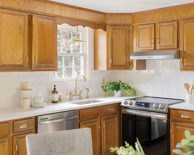 50 Hillside Rd, Tewksbury, MA 01876 - kitchen with stainless steel appliances, under cabinet range hood, a sink, light countertops, and brown cabinets
