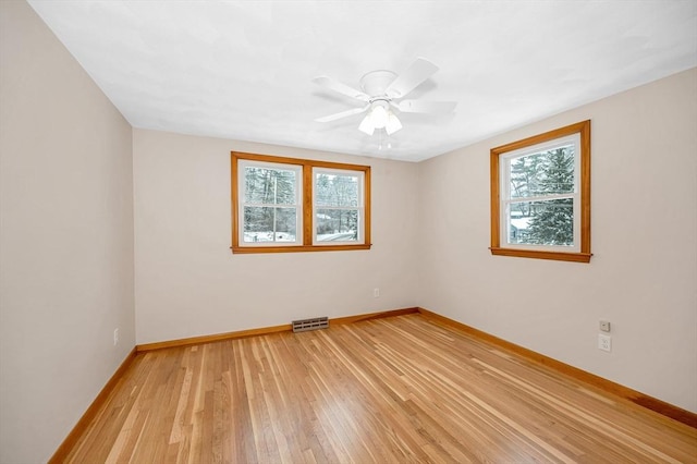 spare room with ceiling fan and light wood-type flooring