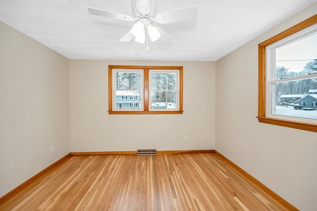 empty room with light hardwood / wood-style flooring, a wealth of natural light, and ceiling fan