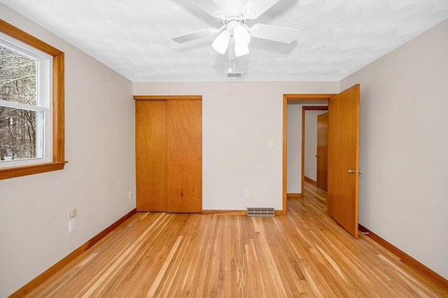 unfurnished bedroom with ceiling fan, a closet, and light hardwood / wood-style flooring