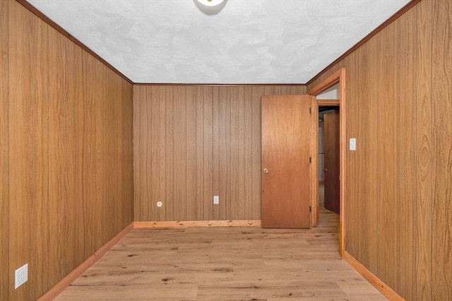 spare room with wooden walls and light hardwood / wood-style floors