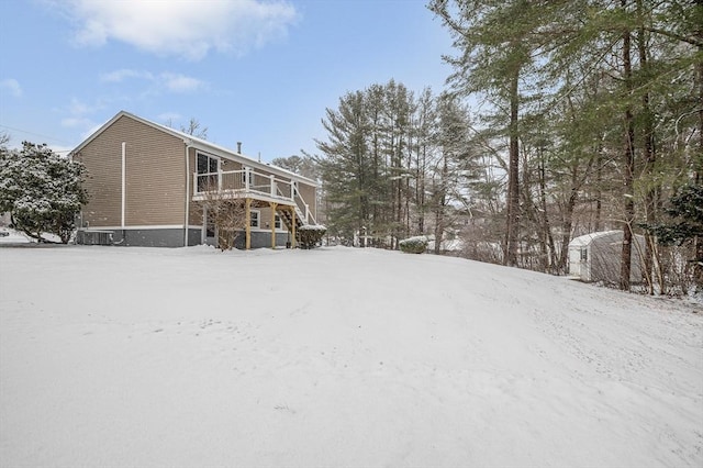 snowy yard featuring a wooden deck