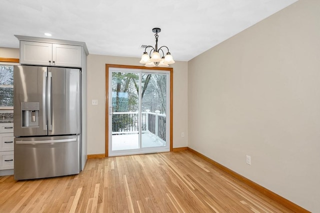 kitchen featuring light hardwood / wood-style flooring, gray cabinets, an inviting chandelier, stainless steel refrigerator with ice dispenser, and decorative light fixtures