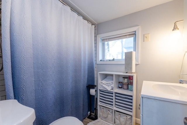 full bathroom featuring toilet, curtained shower, and vanity