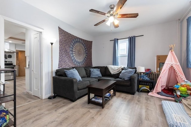 living room with light wood-type flooring, ceiling fan, and baseboards