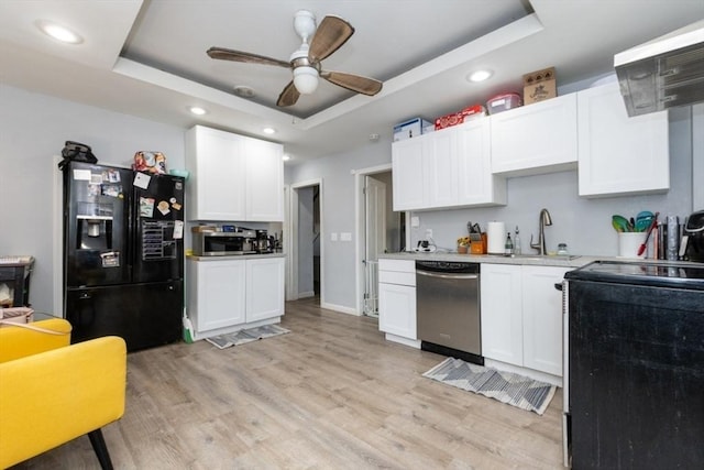 kitchen featuring light wood-style flooring, a tray ceiling, stainless steel appliances, and a sink